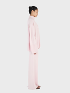 A blush-colored Bay Cashmere Jumper draped elegantly, highlighting its luxurious fabric and stylish silhouette.