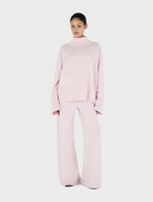 Blush Bay Cashmere Jumper displayed on a hanger, showcasing its soft texture and elegant design.