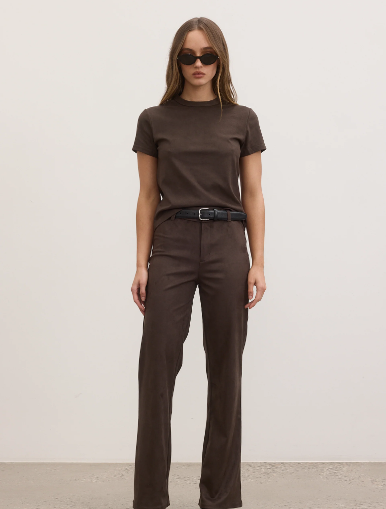 A model showcases a brown t-shirt paired with wide-leg pants, highlighting a casual yet stylish outfit.