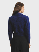 Navy Bella Cashmere Cardigan hanging, featuring a refined design and soft texture ideal for stylish layering.