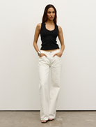 Black Devon tank top laid out, showcasing its modern cut and soft fabric ideal for layering or solo wear.