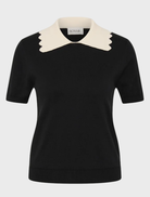 Elegant black knit top with a sleek silhouette, short sleeves, and a contrasting scalloped collar for a vintage touch.