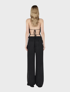 Cropped Iris Halter Top made of black leather, highlighting a chic and edgy look.