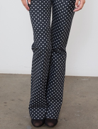 Stylish black trousers with a pattern of small white dots, ideal for both professional and casual wear.