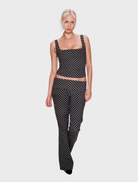 Chic black blouse with a pattern of small dots, ideal for both everyday and dressy occasions.
