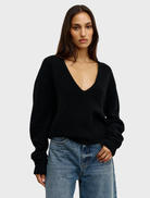 Close-up of a black V-neck top named Sonia, highlighting its neckline and soft material.