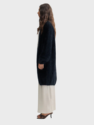 Elegant black cashmere cardigan by Sophia, featuring an open front and long sleeves, hanging against a neutral background.