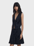 Black vest displayed on a hanger, featuring a sleek design and minimalistic style suitable for various occasions.