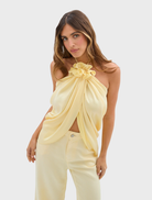 A model showcases the Celeste Jean Pant in pale yellow, paired with a matching top.