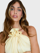 A model showcases a Bloom Halter Top in yellow, paired with stylish yellow pants.