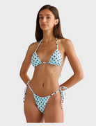 Blue polka dot Rio top draped elegantly, emphasizing its trendy style and fun pattern.