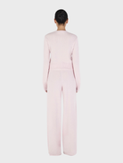 Soft blush Lucielle Cashmere Cardigan draped elegantly, highlighting its luxurious fabric and stylish silhouette.