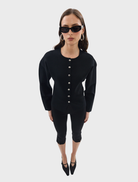 A black Bronte knit cardigan laid flat, highlighting its cozy fabric and relaxed fit.