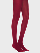A pair of burgundy solid tights laid flat, highlighting their vibrant hue and sleek design.