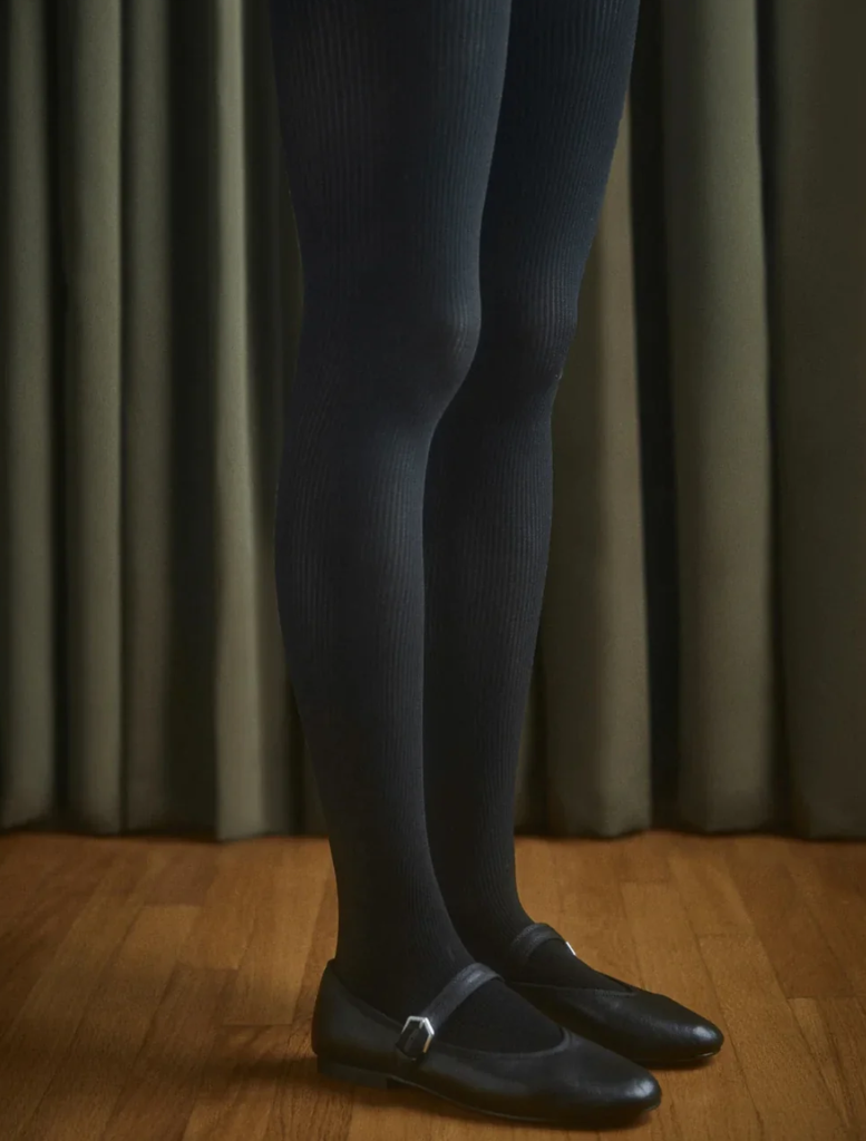 Black cable knit tights displayed on a white background, showcasing their textured pattern and design.