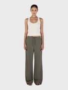 Forest green Caleb pants displayed on a wooden surface, showcasing a sleek design and comfortable fabric.