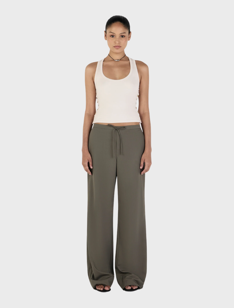 Forest green Caleb pants displayed on a wooden surface, showcasing a sleek design and comfortable fabric.