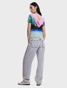 Medium wash denim Cara jeans laid out, emphasizing their timeless straight leg cut and casual appeal against a plain background.