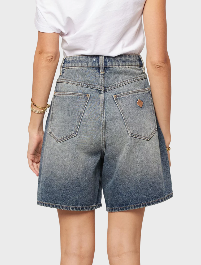 Carrie Short is captured smiling, dressed in a chic outfit, reflecting her vibrant personality and approachable demeanor.