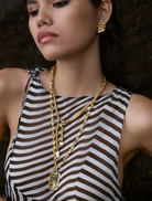 Gold Cassia necklace featuring an elegant design with intricate detailing and a polished finish.