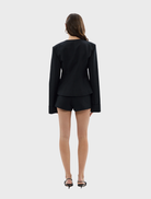 Black Alba Jacket displayed on a hanger, showcasing its sleek design and fabric texture.