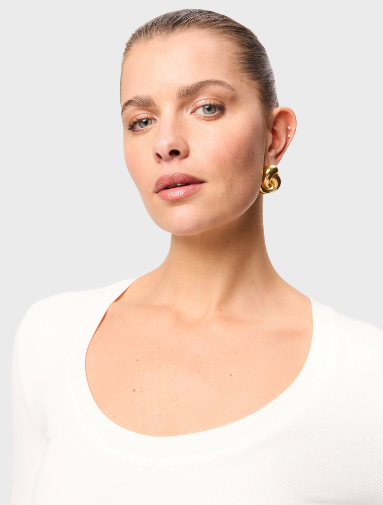 Timeless white Lincoln top with a refined look, perfect for layering or wearing alone for a chic appearance.