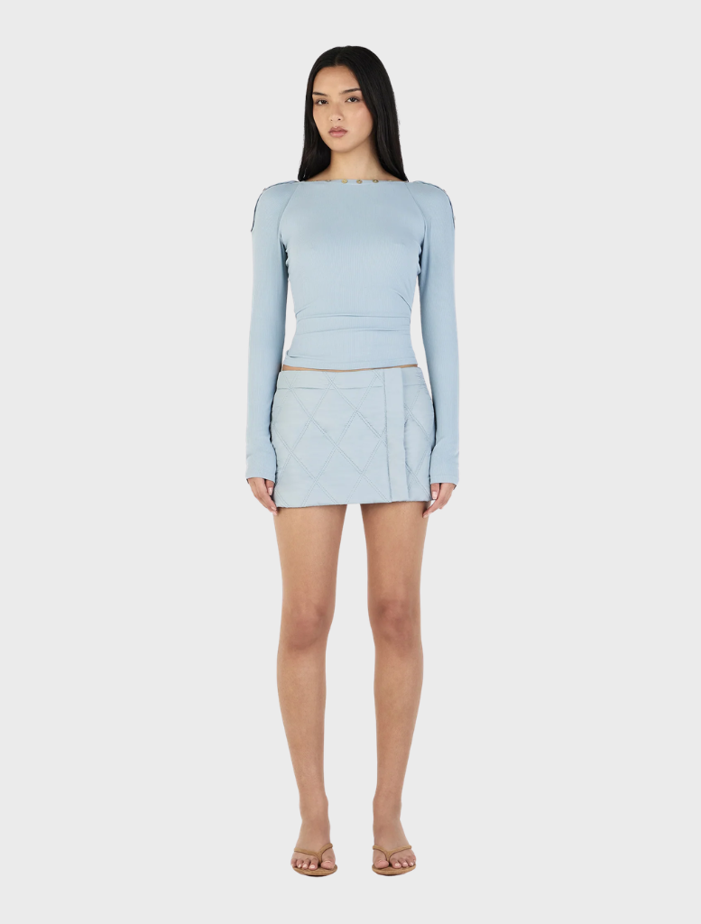 Ice blue Quinn long sleeve top displayed on a hanger, featuring a relaxed fit and soft fabric texture.
