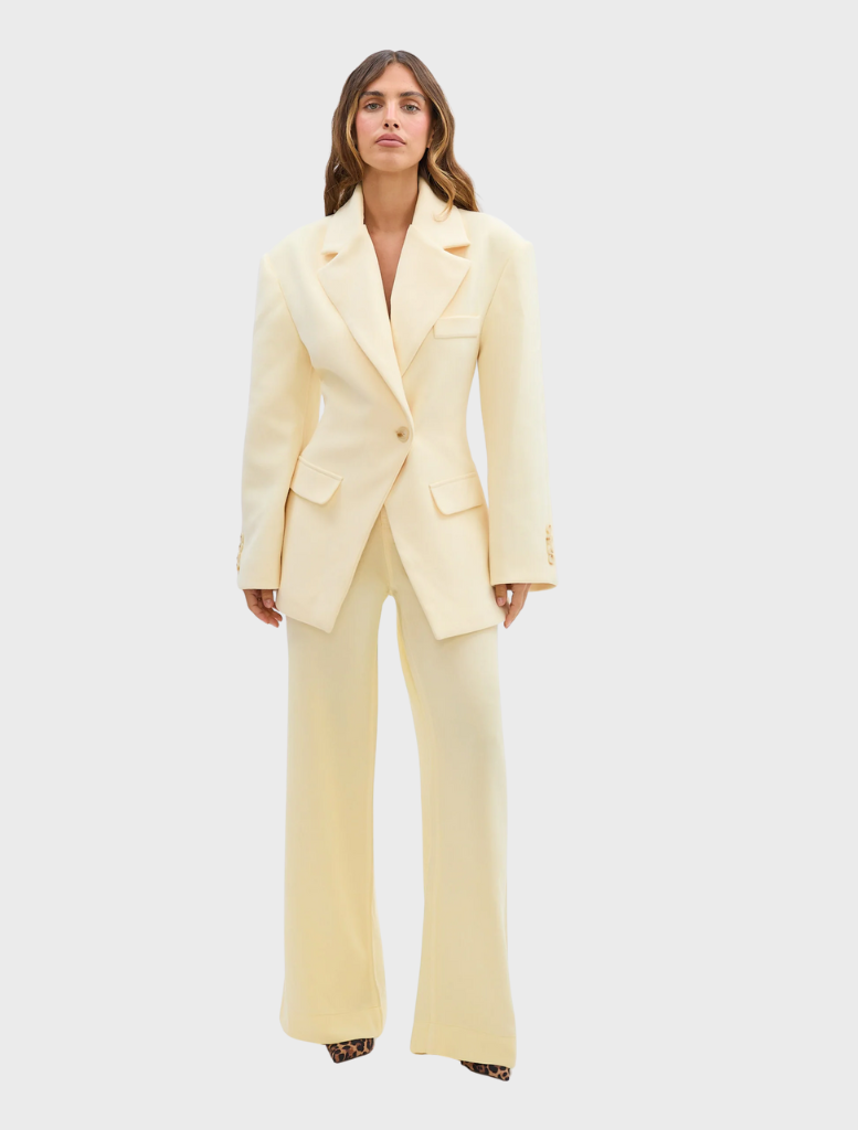A woman in pale yellow pants and a blouse, exemplifying a chic and vibrant style.
