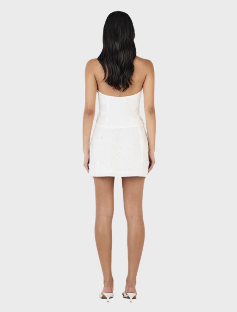 Celina Mini Skirt in white Anglaise fabric, showcasing delicate lace patterns and a chic, modern design.