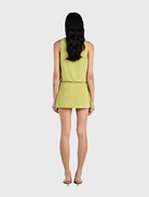 The Chelley Mini Dress showcases a draped bodice, fitted skirt, low cut front, and a stylish front overlay wrap.
