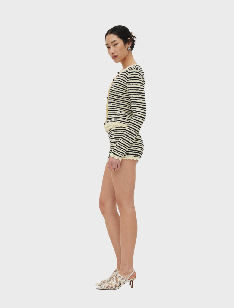Cream and coffee-colored Resonance knit cardigan displayed on a hanger, showcasing its soft texture and stylish design.
