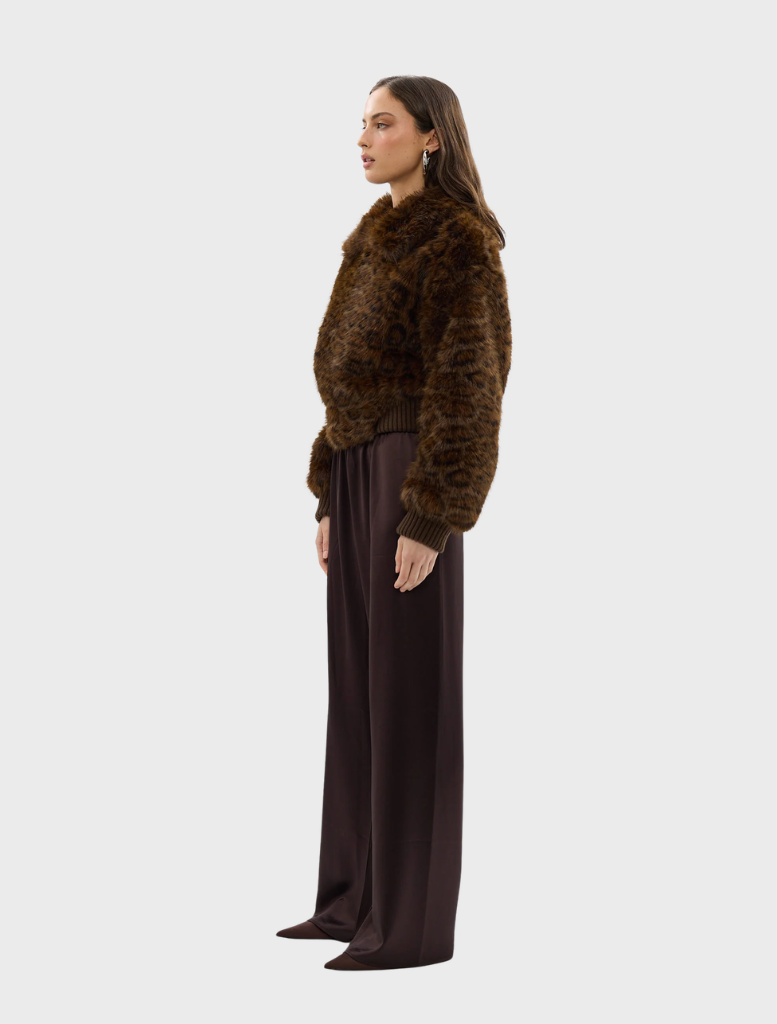 Stylish chocolate leopard faux fur bomber jacket laid flat, featuring its unique print and plush material.