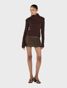 Roxanne turtleneck in chocolate hue, highlighting its sleek silhouette and soft texture, presented on a simple background.