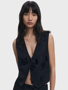 Black vest draped elegantly, illustrating its contemporary design and suitability for both men’s and women’s fashion.