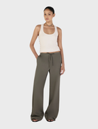 Stylish forest green Caleb pants displayed on a wooden backdrop, focusing on their elegant design and comfortable fit.