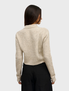 The Claudia V Knit in Urchin, emphasizing its elegant design and vibrant color against a simple backdrop.