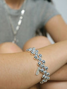 A silver ring embellished with beads, representing the stylish Clover Bracelet.