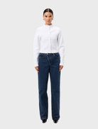 White Carter Cardigan displayed on a hanger, featuring a classic design and soft fabric suitable for casual wear.