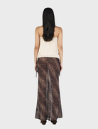 Cream-colored ZOE top displayed on a hanger, featuring a simple design and soft fabric texture.
