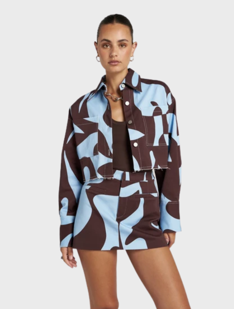 Cropped Shacket in earthy brown and sky-blue, featuring exclusive Mirage artwork, perfect for versatile layering and travel.