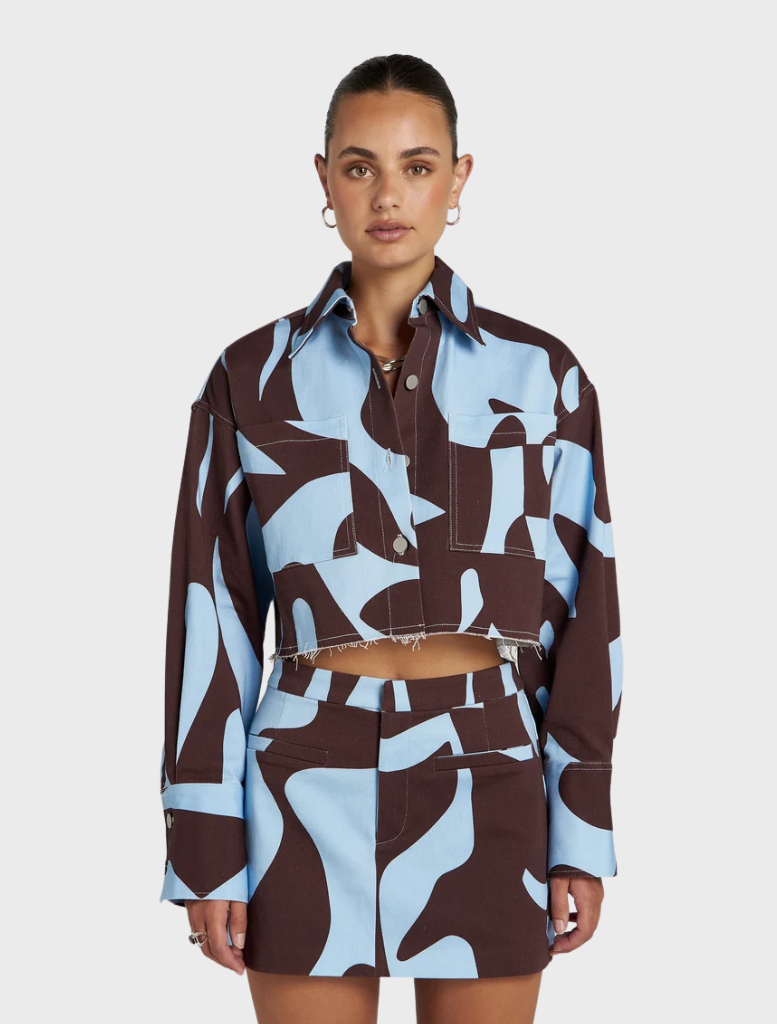 Cropped Shacket in earthy brown and sky-blue, featuring exclusive Mirage artwork, perfect for versatile layering and travel.
