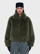 Oversized olive bomber jacket in faux fur, with a standard collar, front zipper, side pockets, and elasticated cuffs and hem.