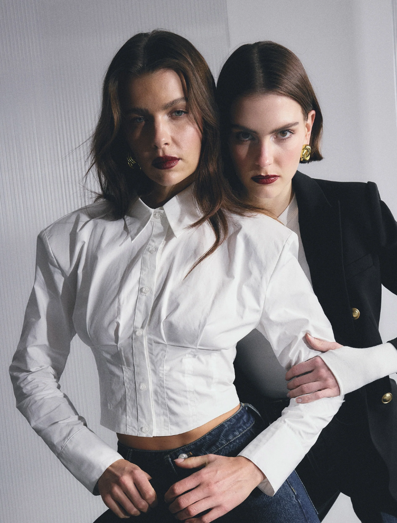 A white Darcy shirt laid flat, showcasing its smooth fabric and tailored design with a button-up front.