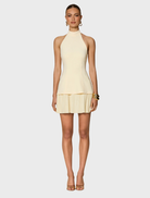 A small, charming lemon-shaped object, bright yellow with a smooth surface, evoking a cheerful and fresh aesthetic.