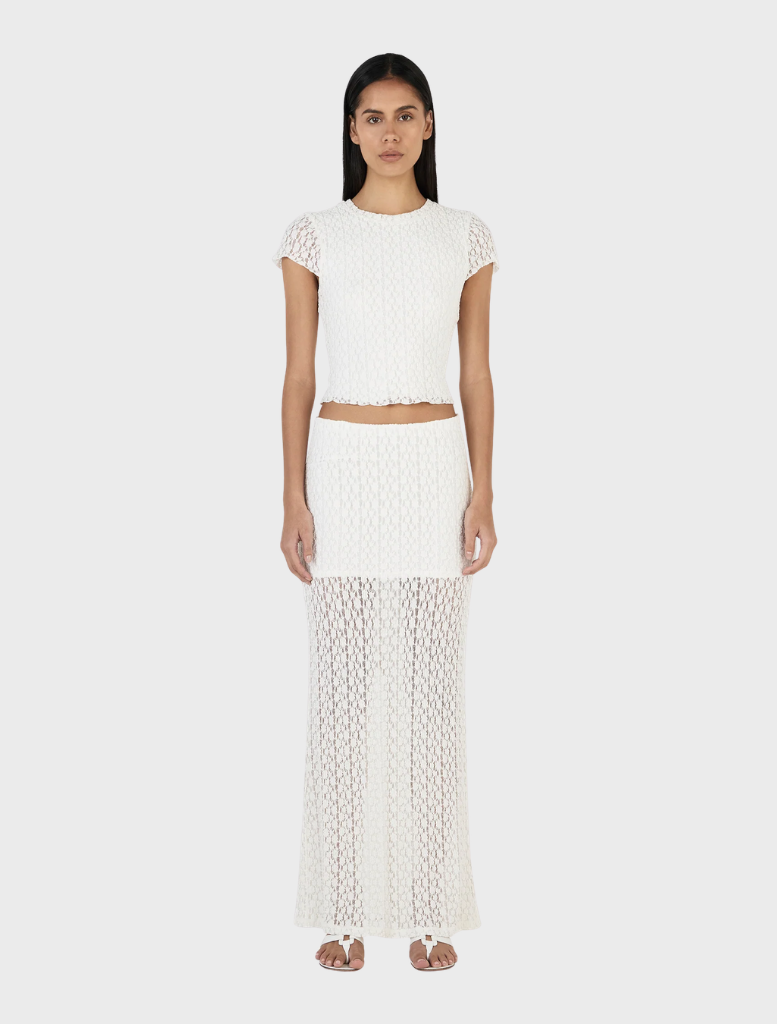 Elegant ivory Delphine skirt shown draped on a hanger, highlighting its soft fabric and stylish silhouette.