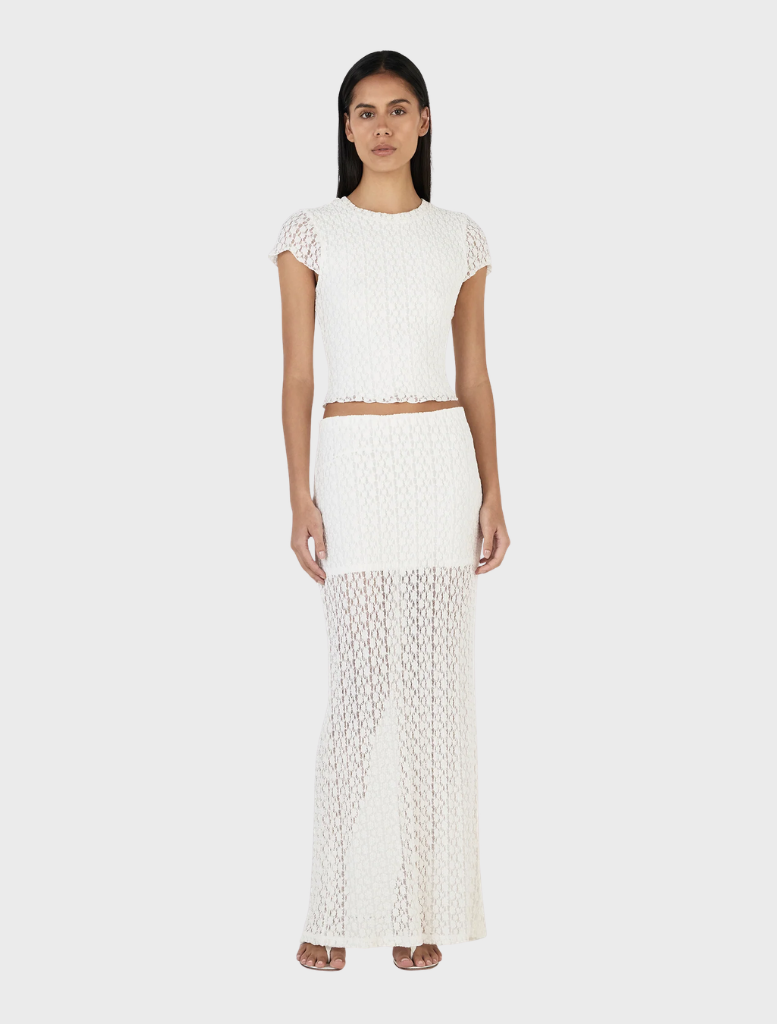 Ivory Delphine skirt laid flat, showcasing its smooth texture and graceful lines, perfect for stylish ensembles.