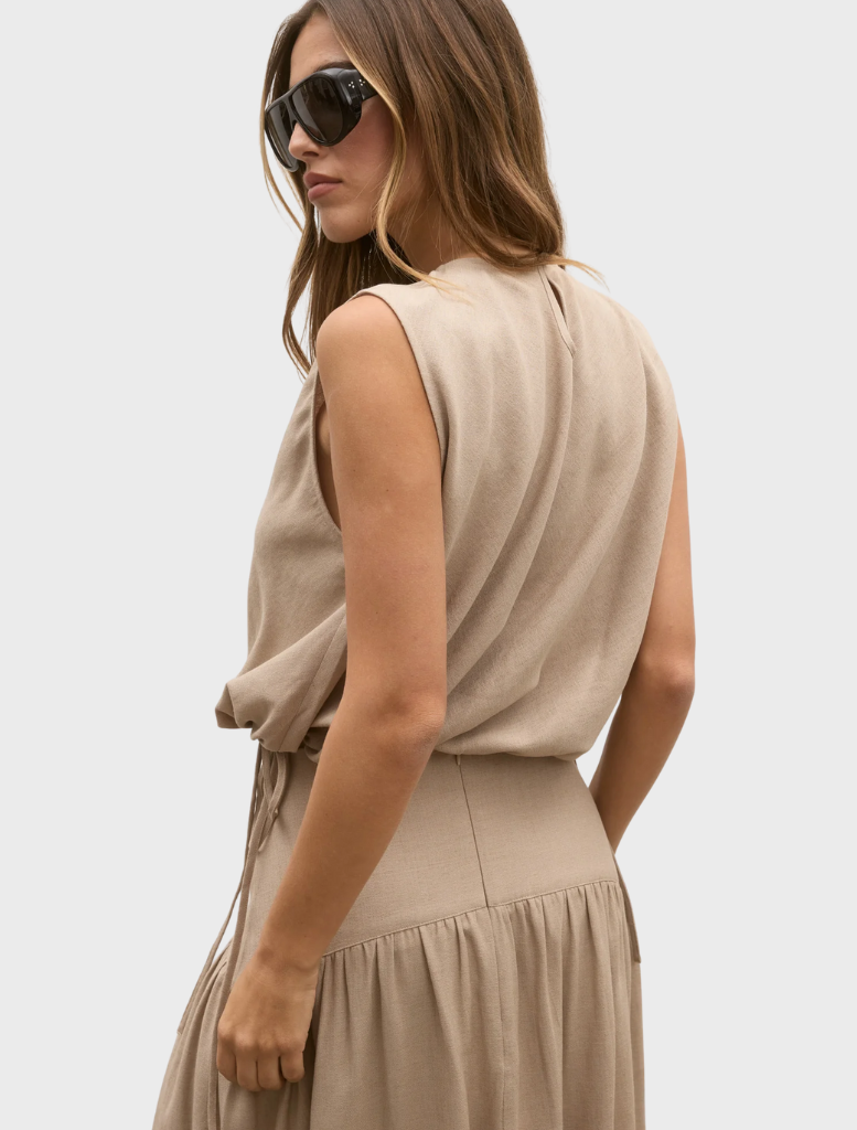 Model dressed in a nude Delphine top and skirt, exemplifying contemporary fashion trends.