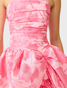 Stunning pink strapless ball gown with a sleek silhouette and dramatic skirt, designed for glamorous occasions.