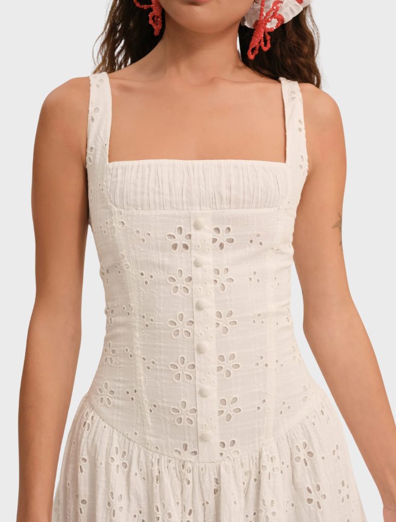 White midi dress featuring a whimsical daisy print, designed with a relaxed fit and gentle draping for a romantic style.