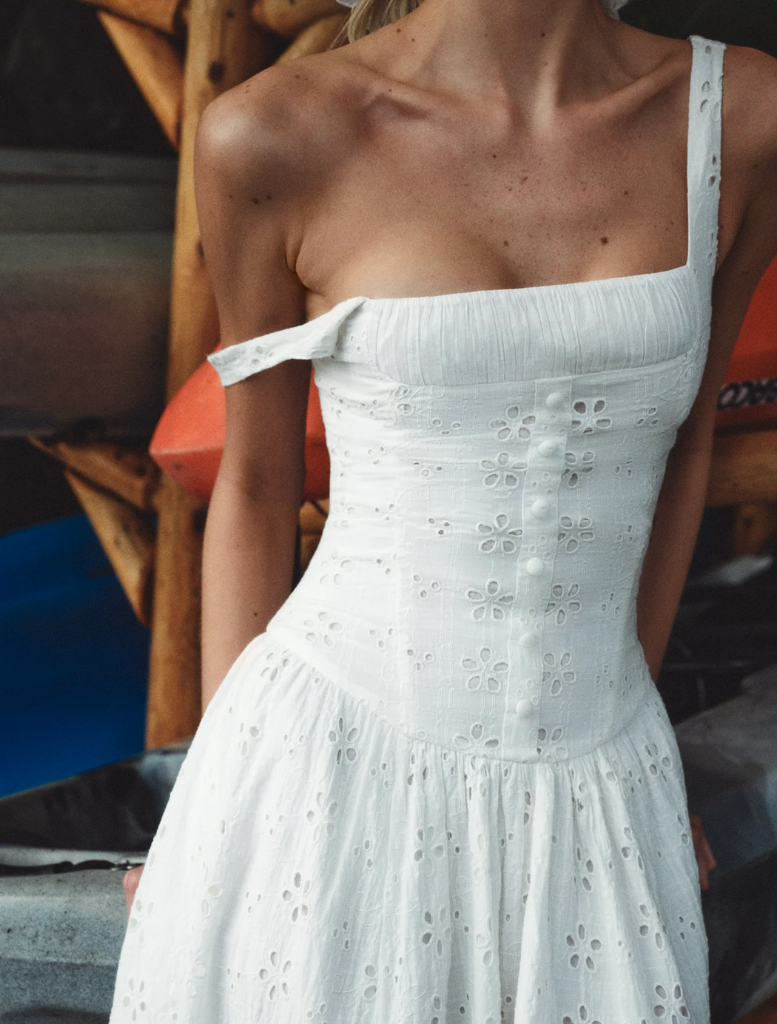 White midi dress with a lovely daisy motif, designed for a flowing fit that enhances a soft, romantic aesthetic.